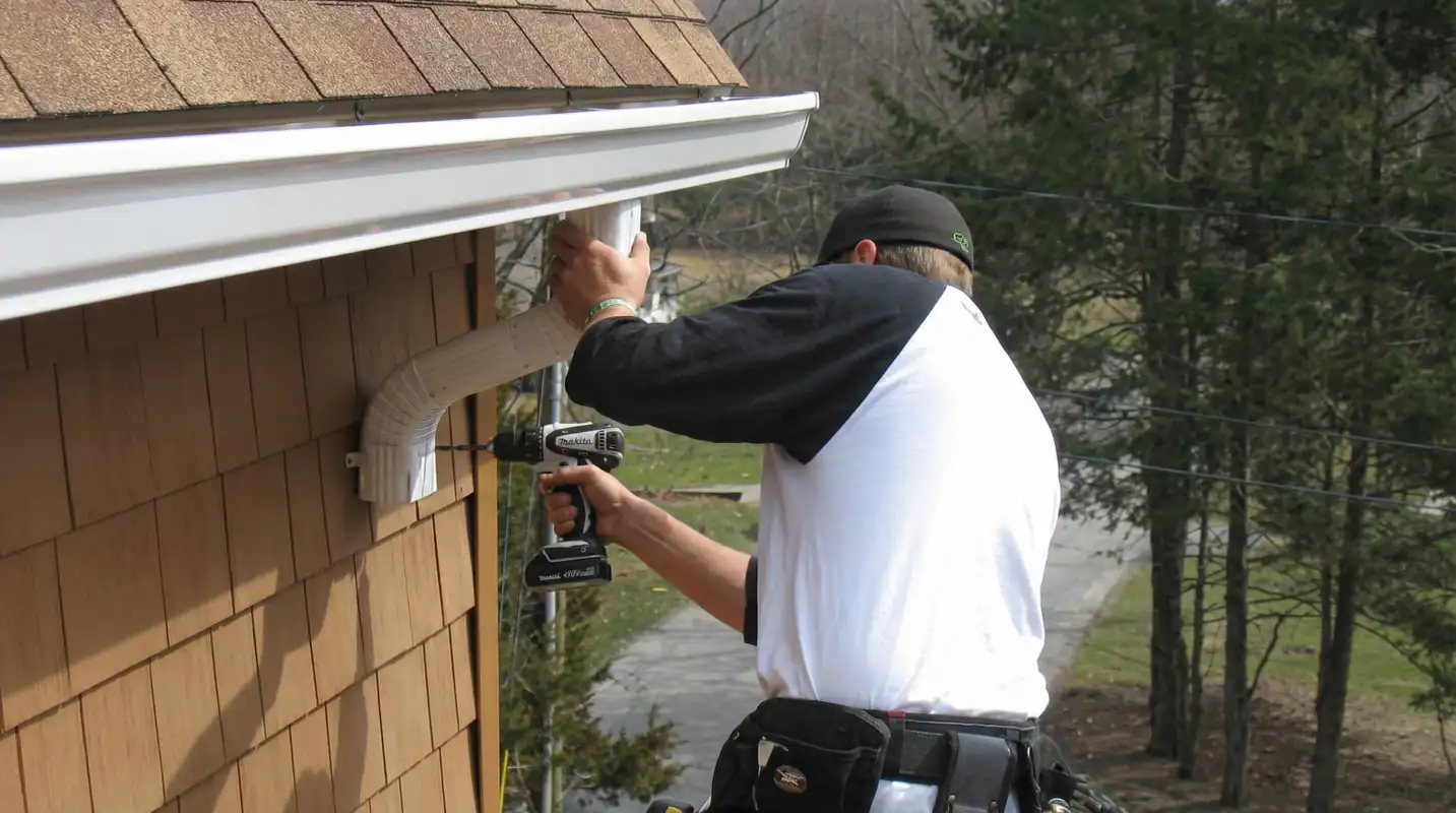 Professional contractor installing tan vinyl siding panels on a residential home exterior in Baton Rouge, LA